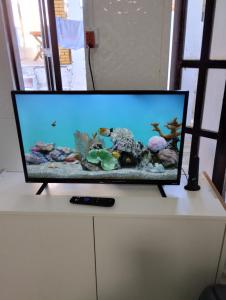 uma televisão de ecrã plano em cima de um armário branco em Casa praia cabuçu - azul com piscina em Saubara