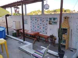 a patio with a wooden table and a table and chairs at Casa praia cabuçu - azul com piscina in Saubara