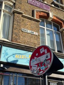 um sinal de rua em frente a um edifício de tijolos em Liverpool Street Green Bedroom em Londres