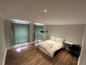 a bedroom with a bed and a desk in it at Liverpool Street Green Bedroom in London