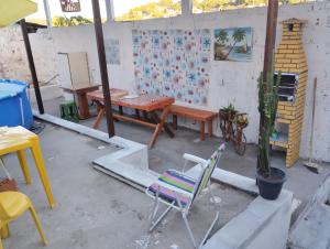 a patio with a table and a chair and a table at Casa praia cabuçu - azul com piscina in Saubara