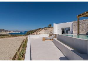 a house on the beach with a swimming pool at Leuki Villa Milos in Adamas