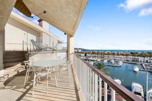 a balcony with a table and chairs and a marina at WELCS APARTAMENTO 106 EMP con PISCINA PRIVADA in Empuriabrava