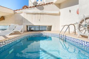 a swimming pool with two chairs and a water wheel at WELCS APARTAMENTO 106 EMP con PISCINA PRIVADA in Empuriabrava