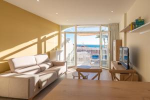 een woonkamer met een bank en uitzicht op de oceaan bij Beach Bungalow Torrox in Torrox