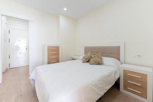 een witte slaapkamer met een groot wit bed met 2 kussens bij Beach Bungalow Torrox in Torrox +11 foto's