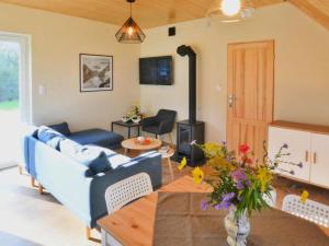 a living room with a couch and a wood stove at Holiday home with private garden close to the lake in Osieki