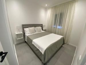 - une chambre blanche avec un lit et une fenêtre dans l'établissement Casa Cova da Onça, à Olhão