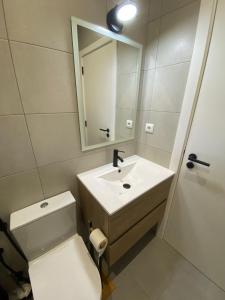 uma casa de banho com um WC, um lavatório e um espelho. em Casa Cova da Onça em Olhão