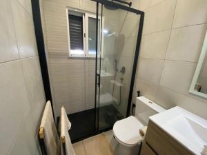 a bathroom with a shower and a toilet and a sink at Casa Cova da Onça in Olhão