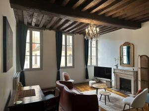 sala de estar con sofá y chimenea en Au roi lion, place Saint Michel, en Dijon
