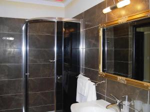 ein Bad mit einer Dusche, einem Waschbecken und einem Spiegel in der Unterkunft Terraced house with pool and sauna, Sieciemin in Sieciemin