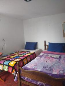 two beds sitting next to each other in a room at Cálida habitación en casa hogareña. Ambiente familiar. in Teziutlán