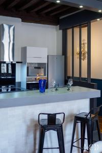 una cocina con una barra grande con dos taburetes en Au roi lion, place Saint Michel, en Dijon