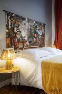 1 dormitorio con 1 cama grande y una pintura en la pared en Au roi lion, place Saint Michel, en Dijon