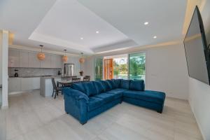 uma sala de estar com um sofá azul e uma cozinha em Ocean One Roatan em West Bay