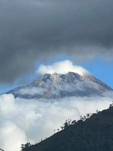 Une montagne enneigée avec des nuages devant elle dans l'établissement Glamping Akaya, à Ibagué
