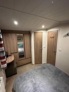 a bedroom with a large bed and a sink at Luxurious 6 Berth Swift Bordeaux on Lyons Robin Hood Rhyl in Meliden