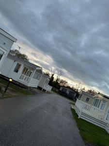 a group of houses with white fences on a street at Luxurious 6 Berth Swift Bordeaux on Lyons Robin Hood Rhyl in Meliden