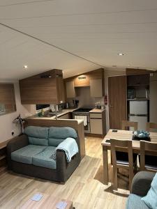 a living room with a couch and a kitchen at Luxurious 6 Berth Swift Bordeaux on Lyons Robin Hood Rhyl in Meliden