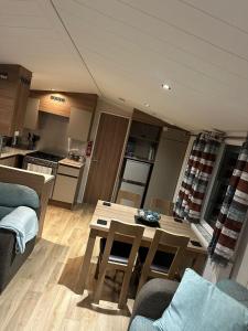 a living room with a table and a kitchen at Luxurious 6 Berth Swift Bordeaux on Lyons Robin Hood Rhyl in Meliden