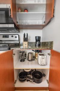 a kitchen counter with pots and pans on a shelf at Luxury 1BD Apt in Downtown Brickell free parking in Miami