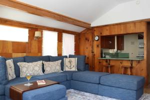 a living room with a blue couch and a kitchen at Catalina Island Cottage - Walk to Main St and Beach! in Avalon