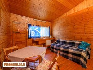 a room with a bed and a desk in a cabin at ערבה גארדן Arava Garden in H̱aẕeva