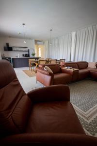 a living room with brown leather couches and a table at Santa Lucia - Villa&Boat in Turanj