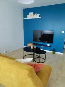 a living room with a couch and a tv at Le Lagon - 10 min aéroport et de Nantes in Rezé