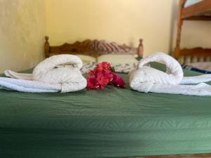 two towels on top of a bed with flowers at Playa Casa Nohelia in Santo Domingo