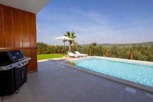 a swimming pool in a house with a kitchen and an outdoor grill at Santa Lucia - Villa&Boat in Turanj