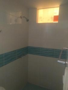 baño con ducha y ventana en Hostal Chachani, en Zamacola