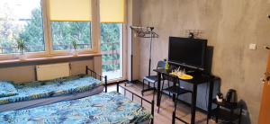 a room with two beds and a flat screen tv at Zaciszne pokoje in Warsaw