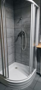 a shower with a glass door in a bathroom at Zaciszne pokoje in Warsaw