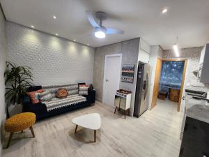uma sala de estar com um sofá e uma cozinha em Maresias Beach Home - Mata Azul em Maresias