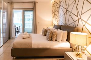 1 dormitorio con 1 cama grande con almohadas en Luxury Seafront 3beds Flat + Pool, en Sliema