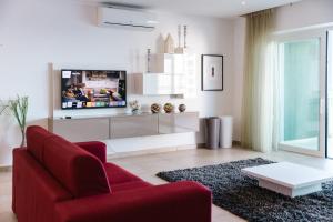 sala de estar con sofá rojo y TV en Luxury Seafront 3beds Flat + Pool en Sliema