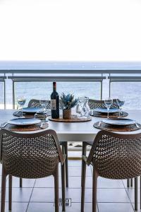 una mesa con una botella de vino y dos sillas en Luxury Seafront 3beds Flat + Pool, en Sliema