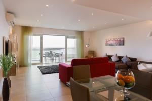 a living room with a red couch and a table at Luxury Seafront 3BR with Pool by Arco Collection in Sliema