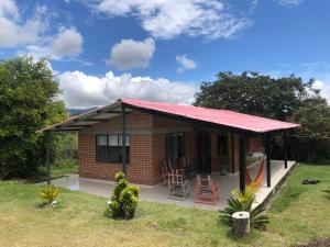 a small brick house with a red roof at Finca en Cimarrones, Chachagui - Fundadores in Chachagüí