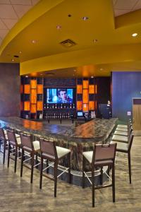 un bar en un hotel con sillas y TV en Shoshone Rose Casino & Hotel, en Lander