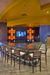 a bar in a hotel with chairs and a television at Shoshone Rose Casino & Hotel in Lander