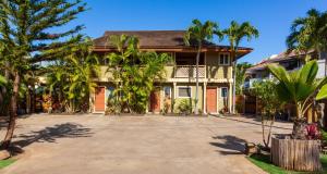 a house with palm trees in front of it at Studio Boutique Resort Across from Beach in Kihei