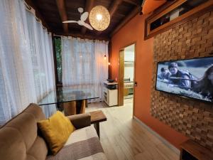 un soggiorno con un divano e una TV a parete di Maresias Beach Home - Mata Azul a Maresias