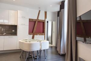 cocina con armarios blancos, mesa y sillas en MY SWEET HOMES - Appartements avec SPA, en Colmar