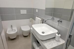 a white bathroom with a sink and a toilet at Altamarea Beach Experience Villetta LC in Marina di Pescoluse +25 photos