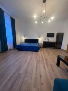 Duży pokój z łóżkiem i drewnianą podłogą w obiekcie Comfort Center w Bytomiu