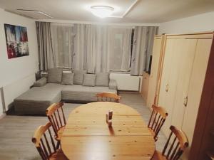 uma sala de estar com uma mesa de madeira e cadeiras em Altstadthaus Marille mit Innenhofterrasse em Melk