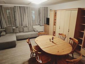 uma sala de estar com uma mesa de madeira e cadeiras em Altstadthaus Marille mit Innenhofterrasse em Melk